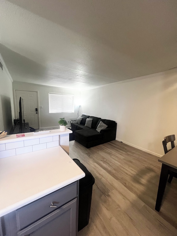 A compact living space with a kitchenette, a dining area, and a seating area with a sofa.