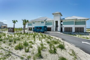 Un club de plage doté d’un bâtiment moderne, d’un fourgon et d’un ciel dégagé.