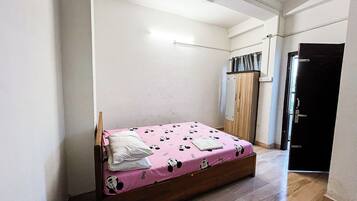 A bedroom with a bed, wardrobe, and a door.