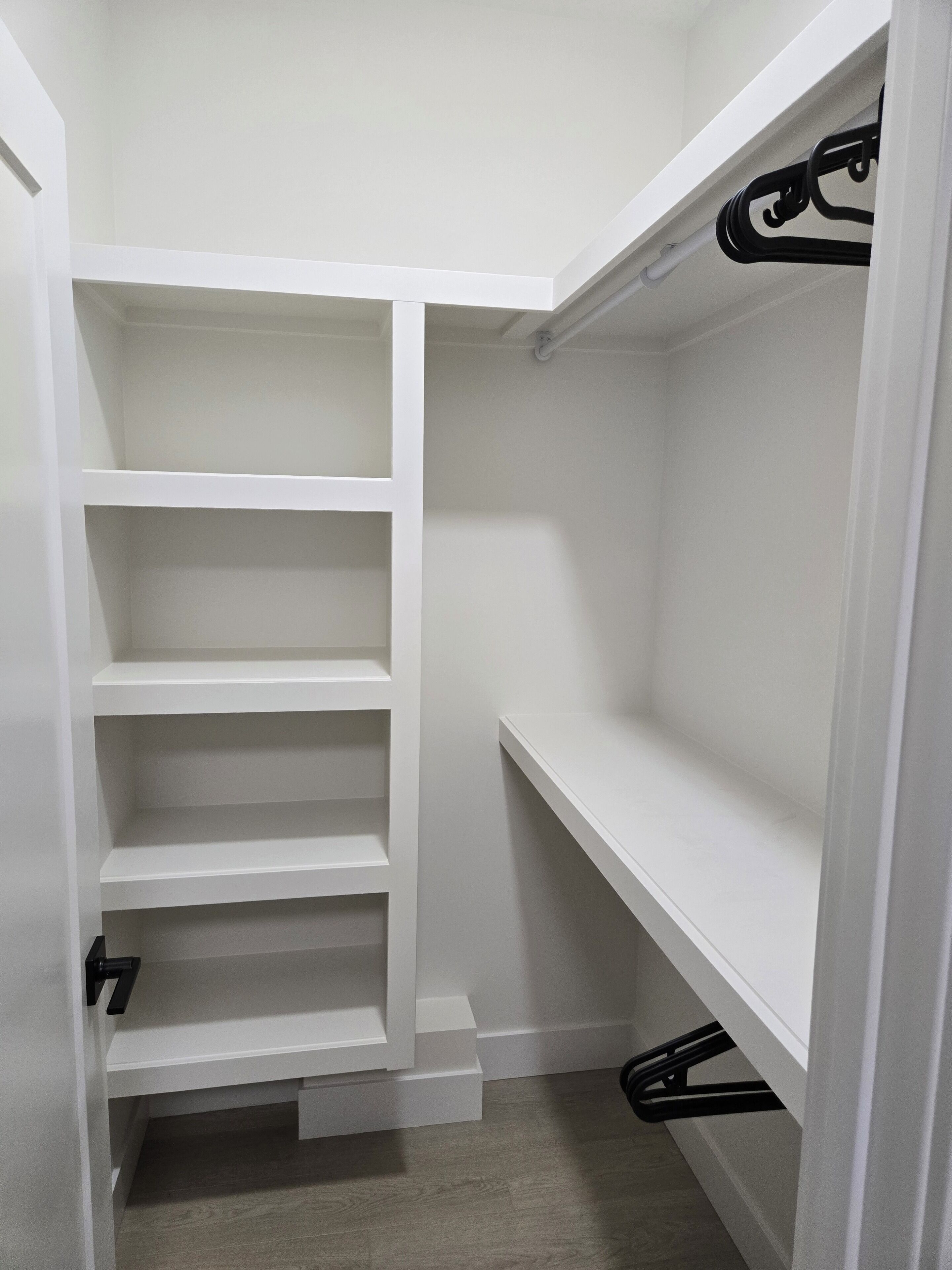 Un armario vestidor con amplias repisas y espacio para colgar.