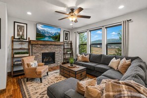 A living room with a fireplace, a sofa, a coffee table, and a bookshelf. - Deer Valley Grand Residence 4BR 10 min from skiing (Hideout)