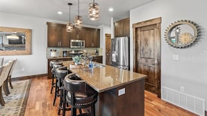 A modern kitchen with granite countertops, stainless steel appliances, and a central island with bar stools. - Deer Valley Grand Residence 4BR 10 min from skiing (Hideout)