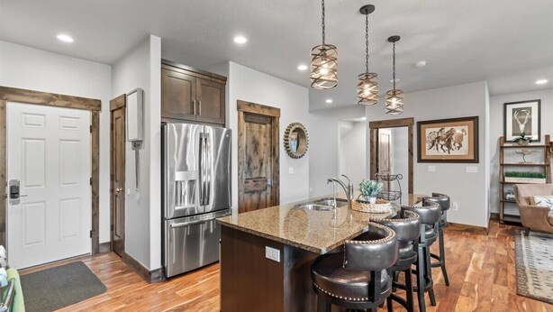 A modern kitchen with a central island, stainless steel appliances, and a bar area with stools. - Deer Valley Grand Residence 4BR 10 min from skiing (Hideout)