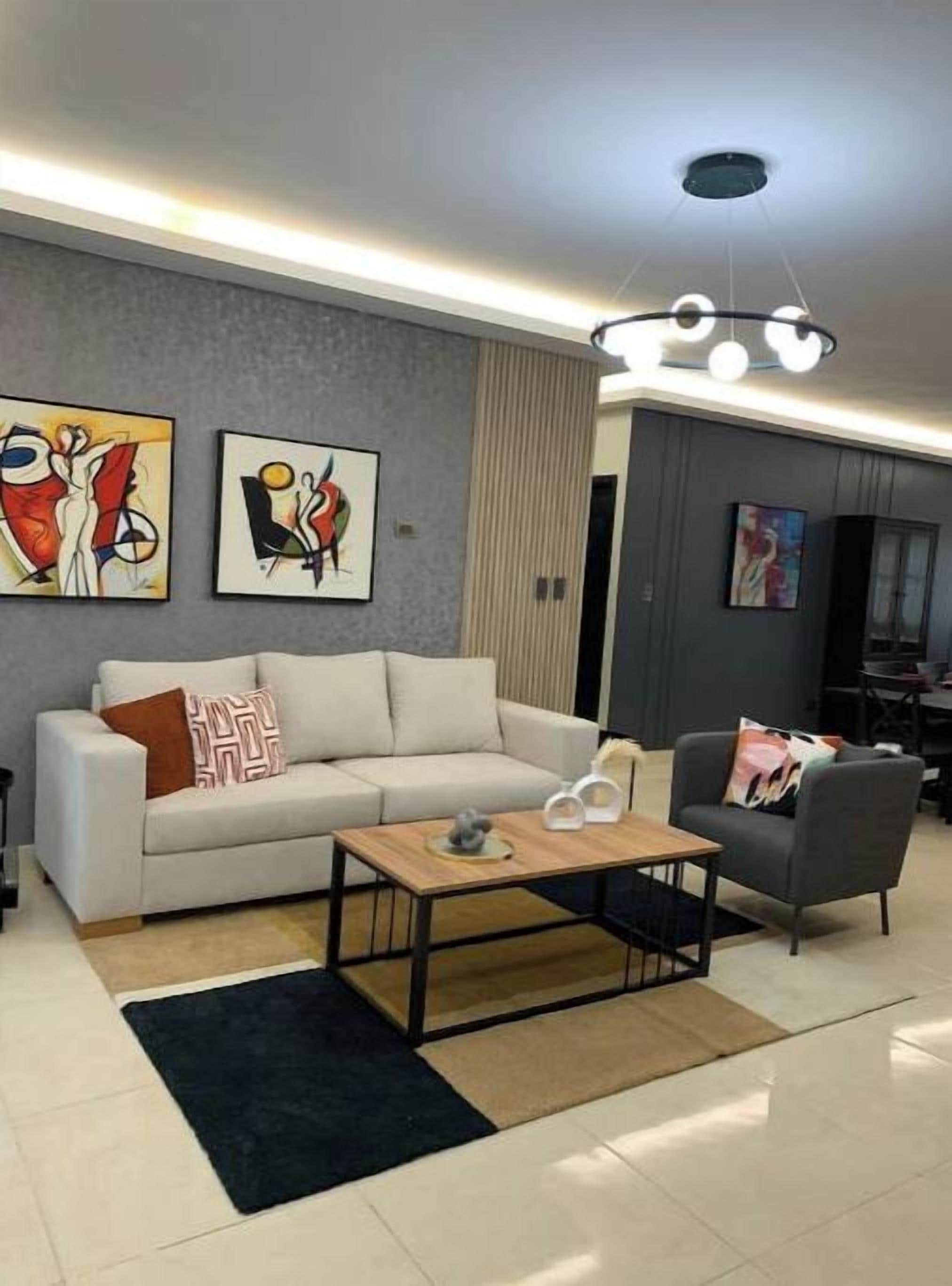 Una sala moderna con sofá, una mesita de centro y una obra de arte en la pared.