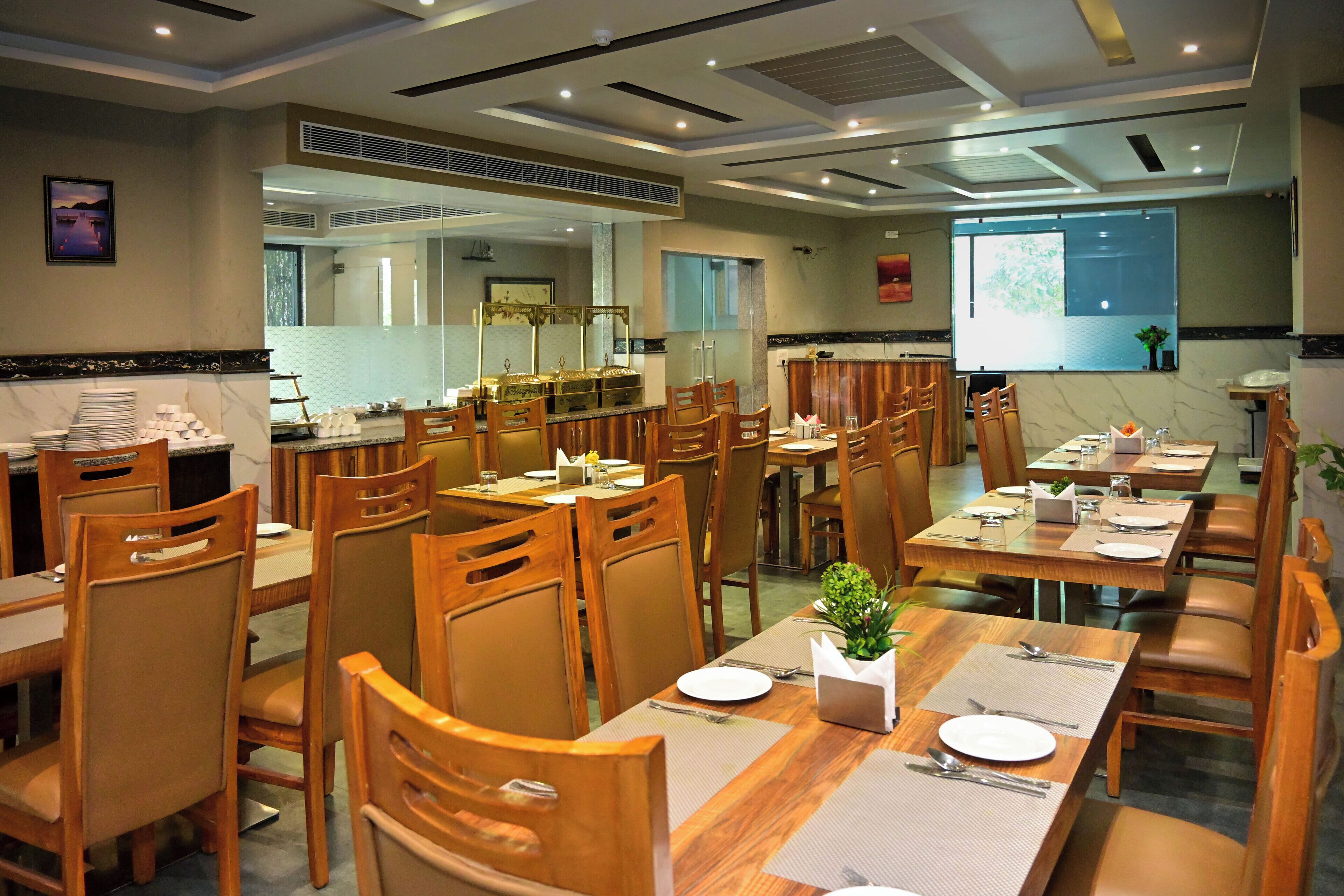 Un restaurant doté de plusieurs tables et chaises, avec une décoration de table soignée et une petite plante en guise de centre de table.