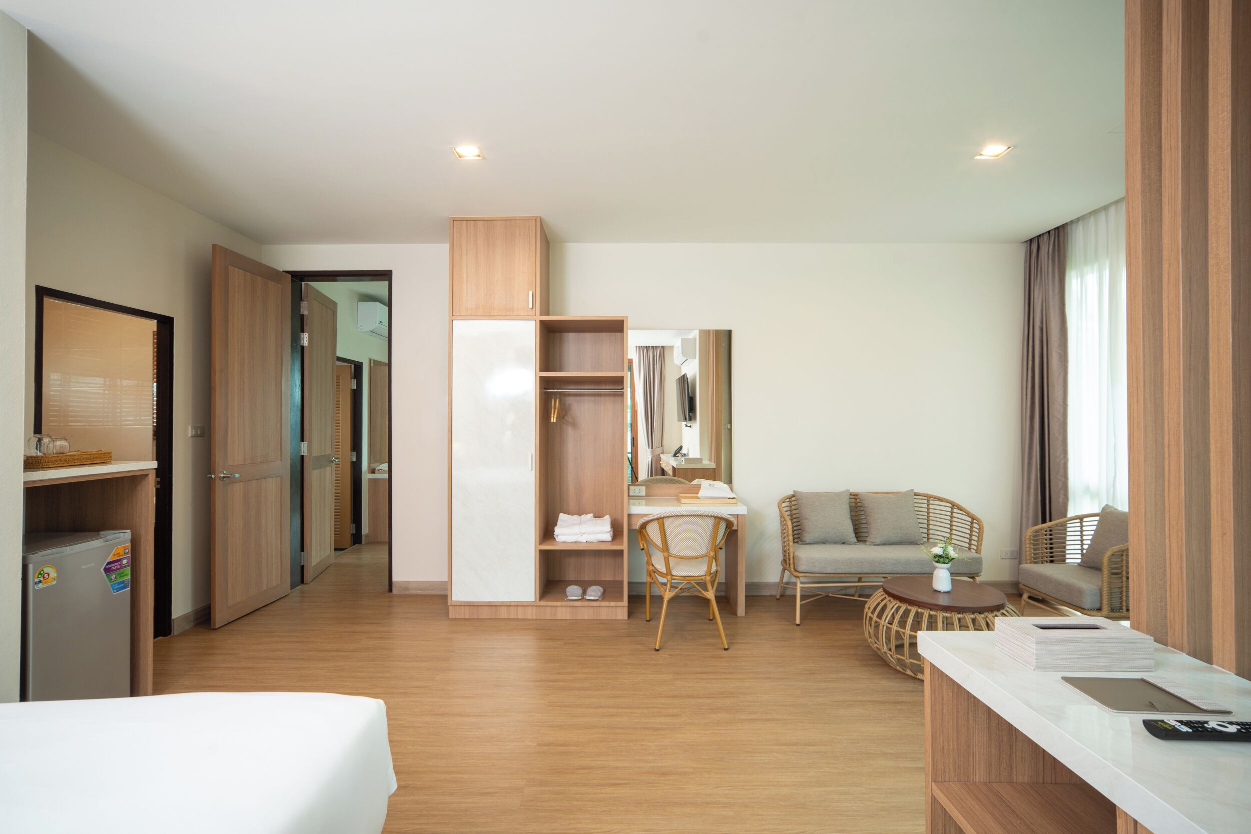 Een hotelkamer met een bed, een bureau, een stoel, een bank, een kledingkast en een kleine tafel.