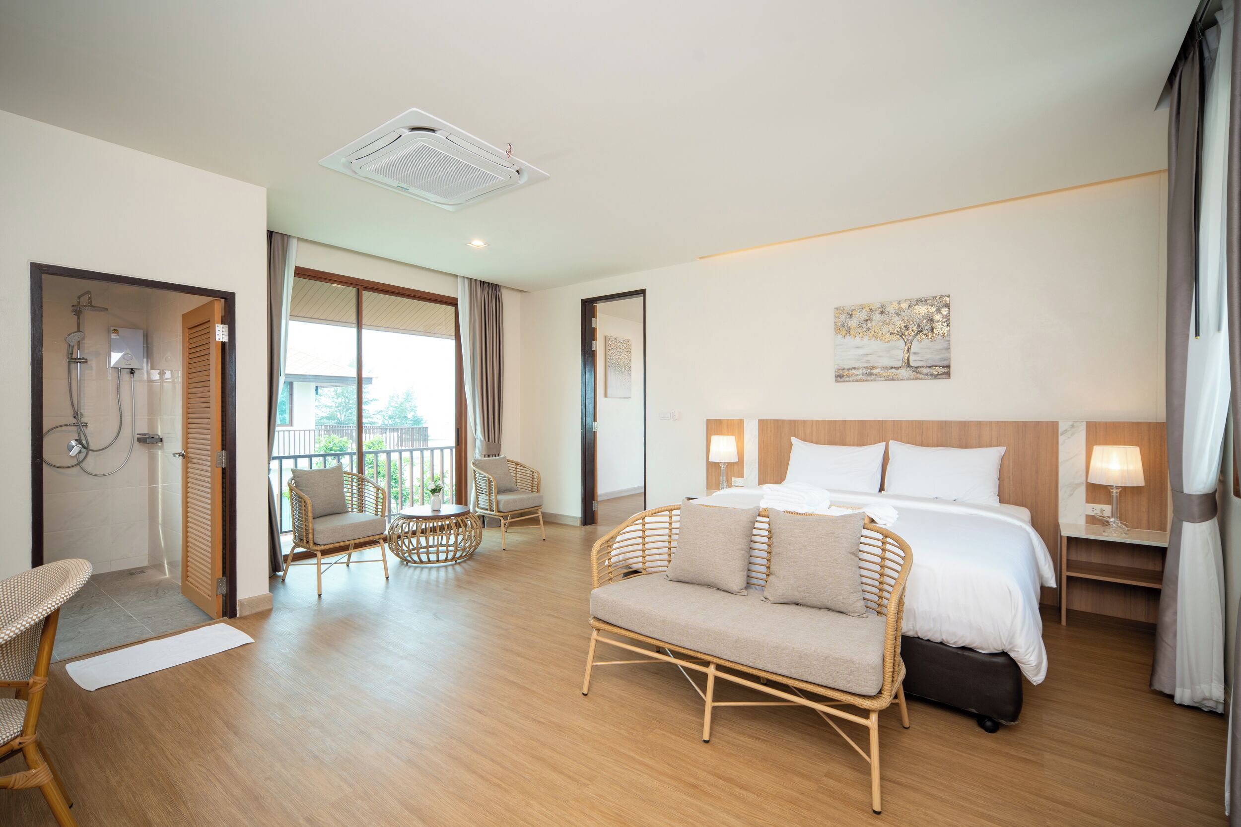 Une chambre d’hôtel comprenant un lit, un canapé, une chaise, un bureau et une salle de bain avec douche.