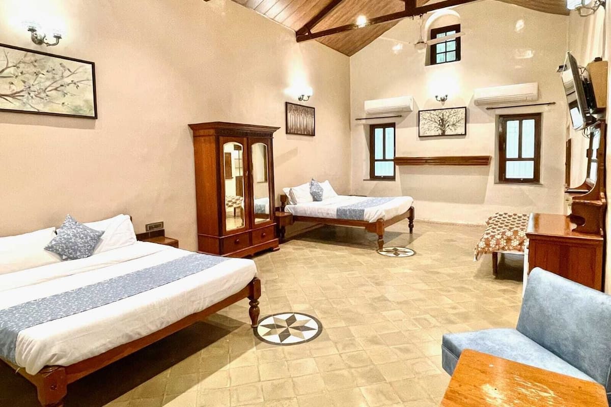 Un dormitorio con dos camas, un armario de madera y un piano.