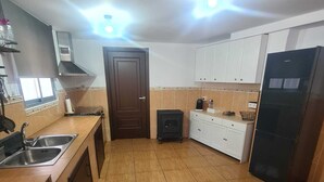 Une cuisine équipée d’un lave-linge, d’une cuisinière, de placards et d’un réfrigérateur.