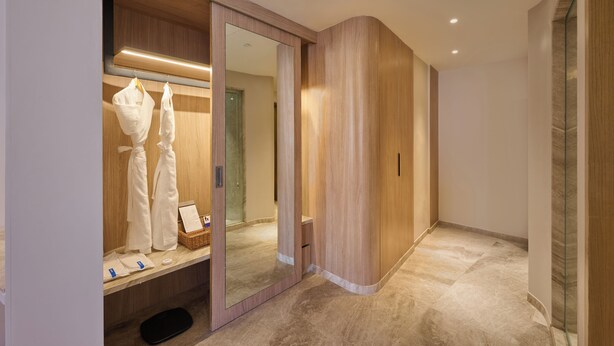 Un baño moderno con tocador de madera, un espejo y zona de ducha.