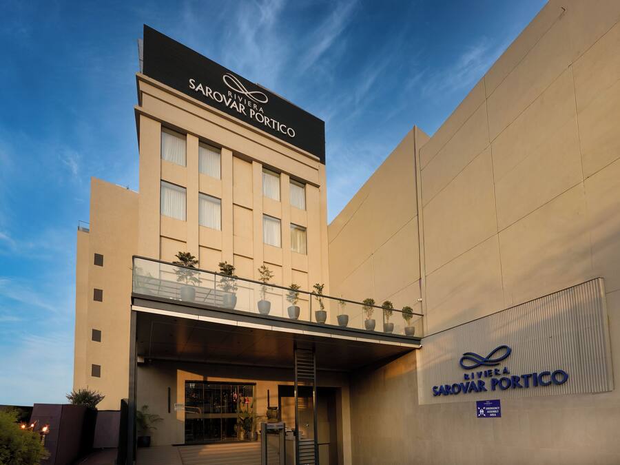 Un edificio moderno con un letrero que dice 'Rivera Sarovar Portico'.