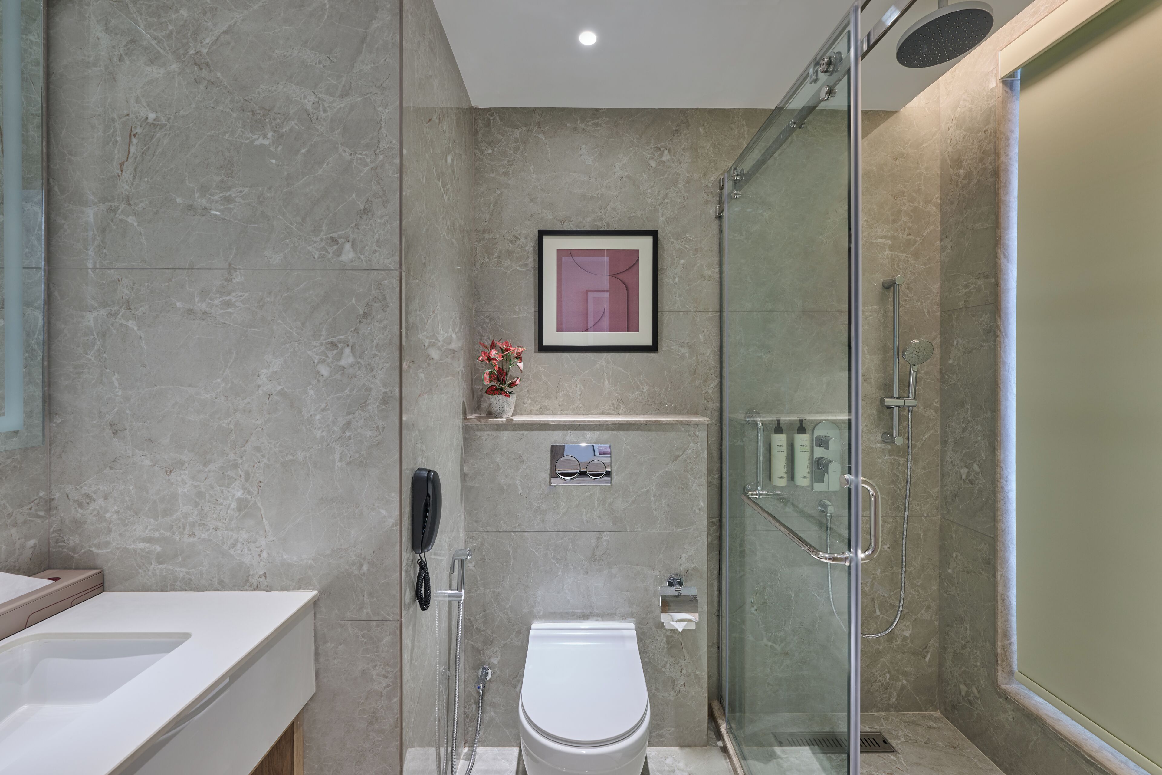 A modern bathroom with a glass shower enclosure, a toilet, and a vanity with a sink.