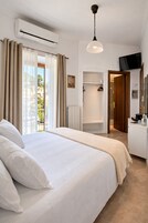 Habitación de hotel con cama, ducha, televisión y vistas a edificios.