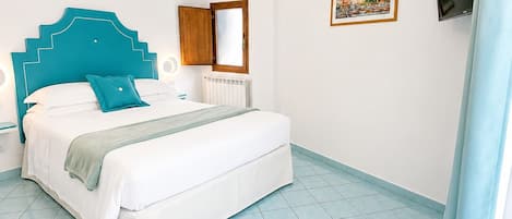Un dormitorio con cama, mesita de noche, ventana, equipo de aire acondicionado, un cuadro y televisor.