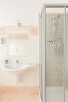 Un baño con lavamanos, espejo y ducha.