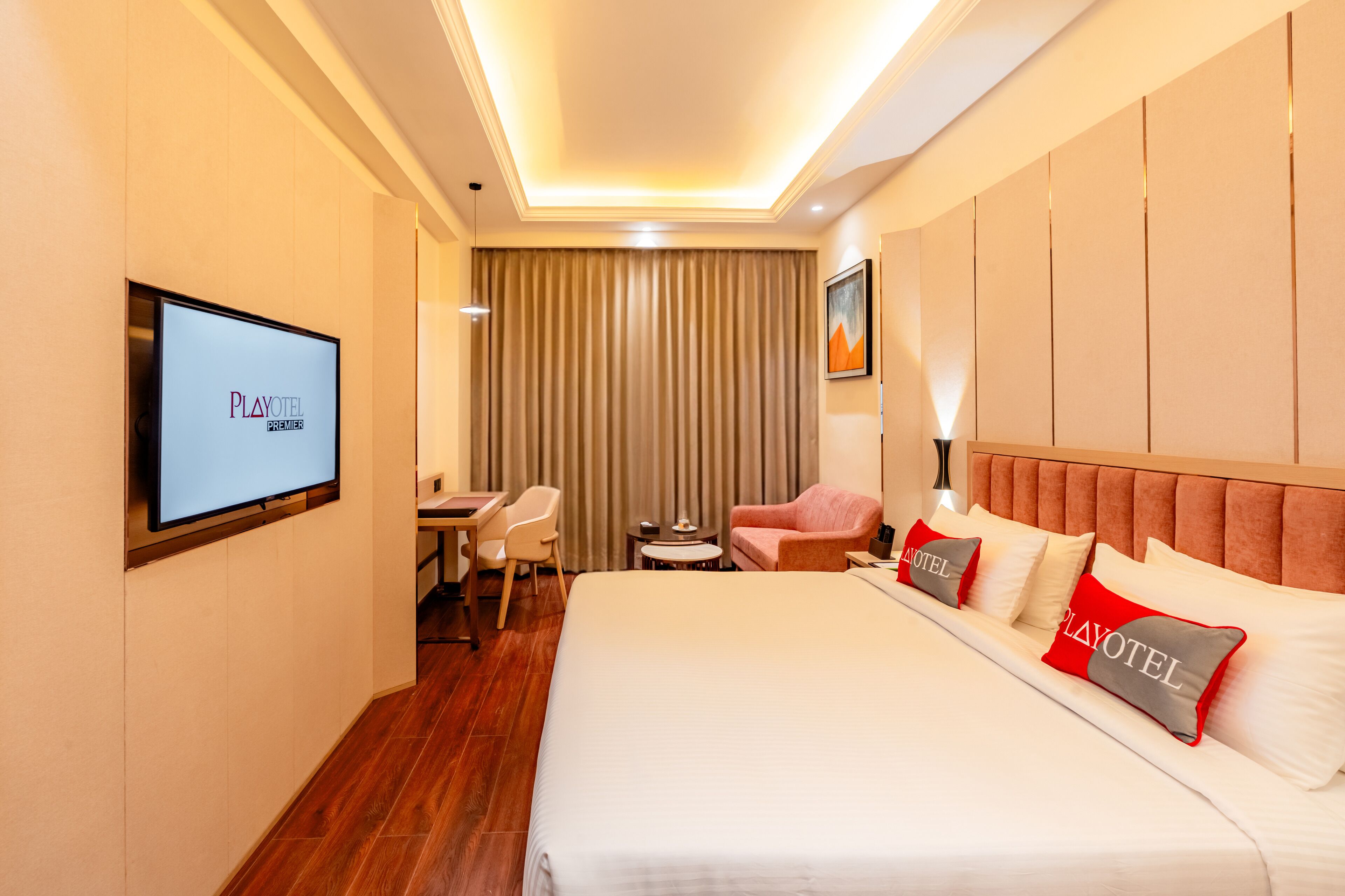 A hotel room with a bed, a desk, a chair, a TV, and a curtain.