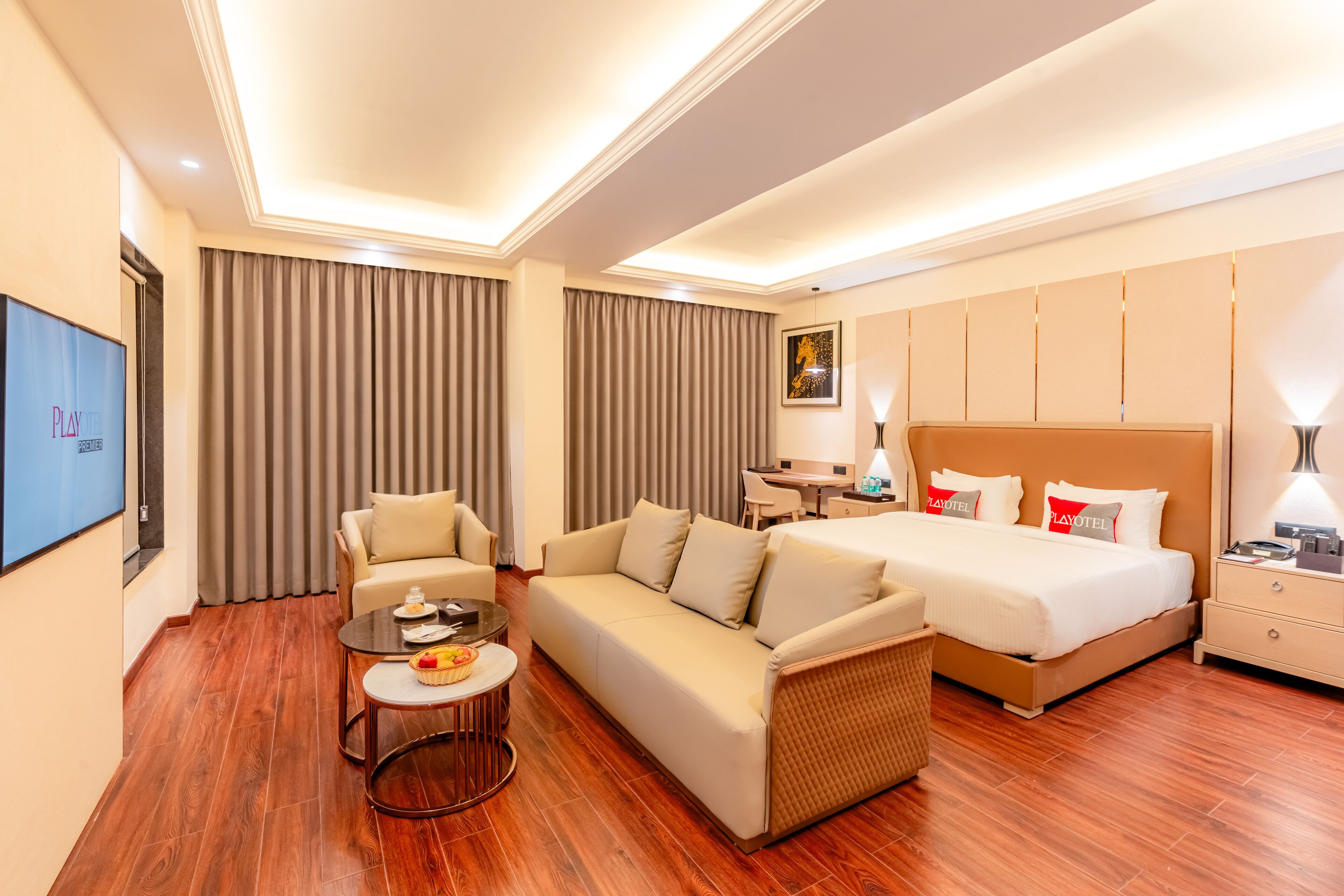 Une chambre d’hôtel moderne équipée d’un canapé, d’un lit, d’un bureau et d’une télévision.