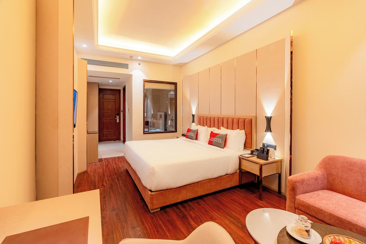 Une chambre d’hôtel avec un grand lit, un bureau, une chaise et un canapé.