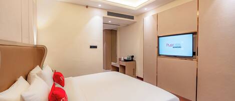 Una habitación de hotel con una cama, un televisor en la pared y un escritorio con una silla.