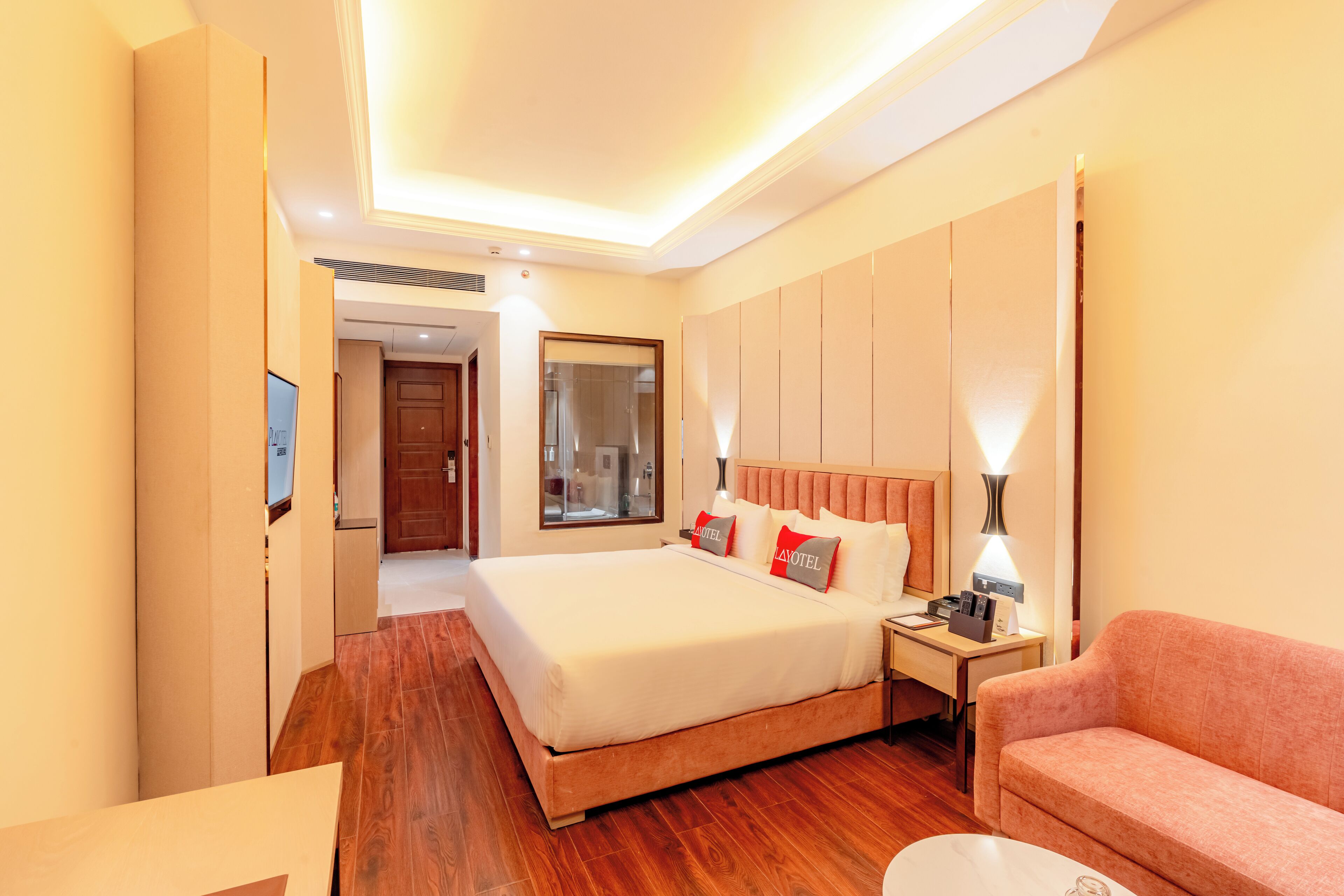 Une chambre d’hôtel avec un grand lit, un bureau, un canapé et une télévision.