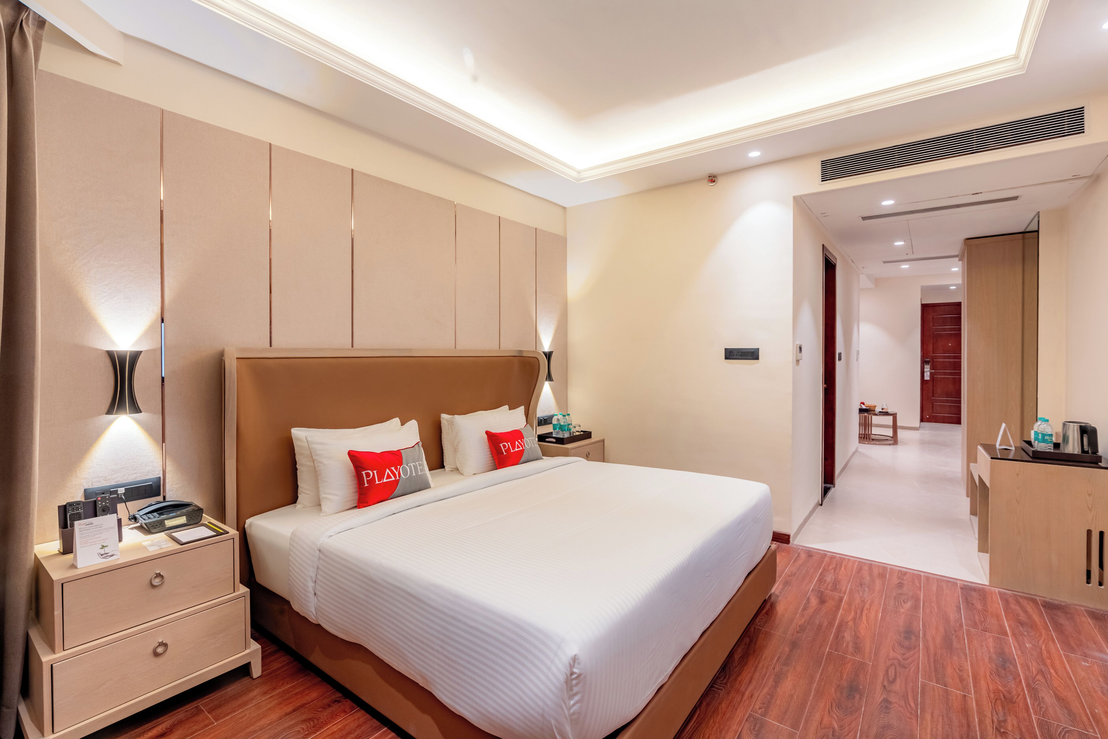Een moderne hotelkamer met een groot bed, nachtkastjes, een bureau en een kledingkast.