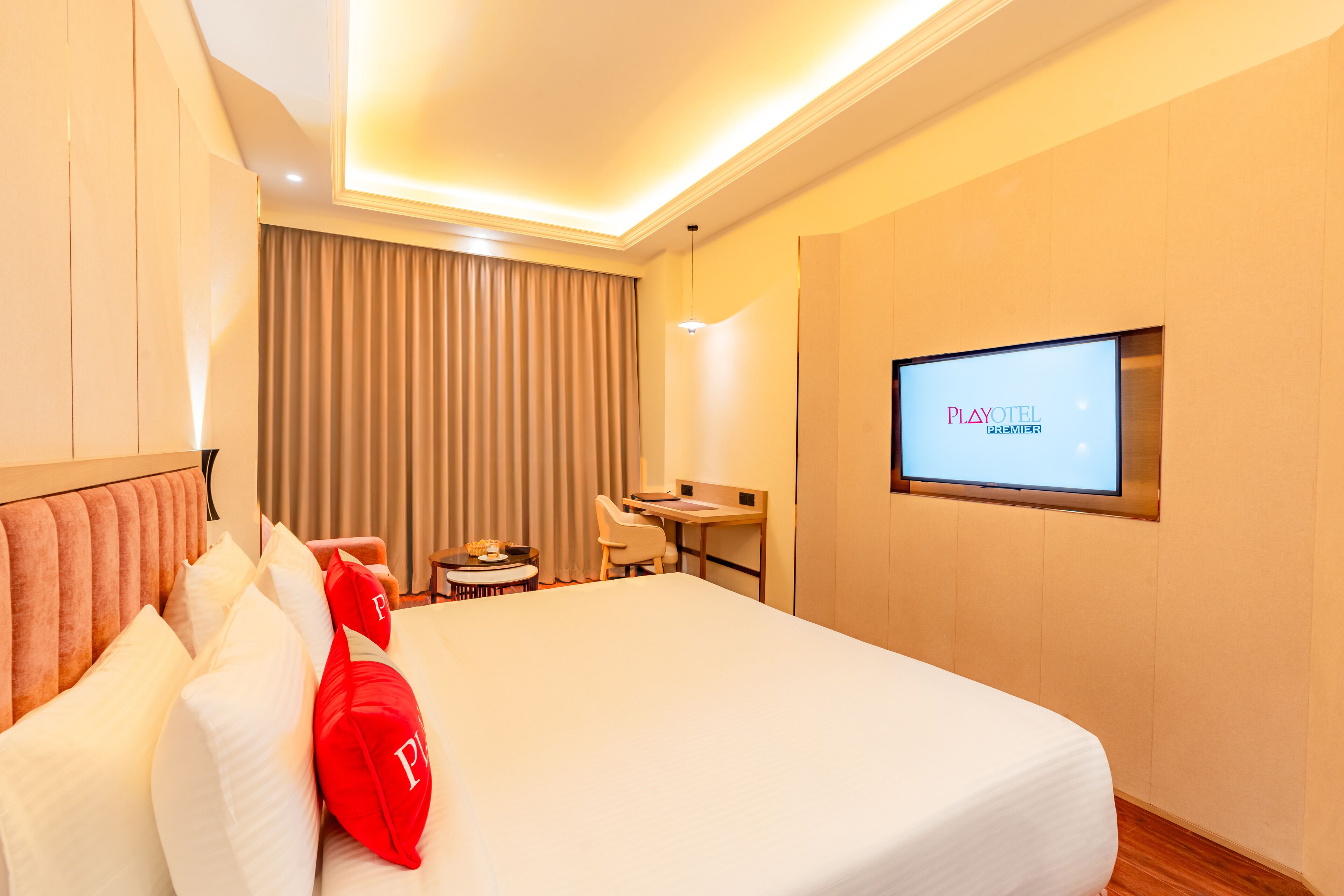 A hotel room with a bed, a desk, a chair, a television, and a curtain.