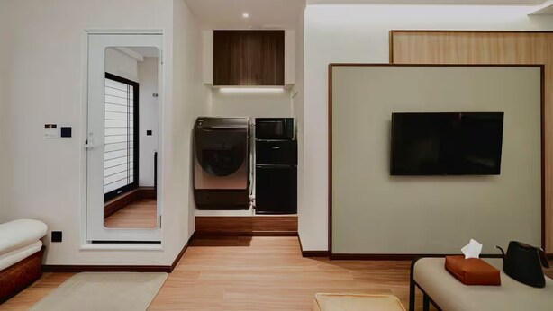 A modern living room with a flat-screen TV, a sofa, and a small table. - hokkawaakihabara (Tokyo)