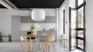 Une cuisine moderne avec une table de salle à manger ronde, quatre chaises et un vase de fleurs.