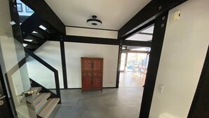A modern interior with a staircase, a wooden cabinet, and a large window. - Holiday Home 'Mit Ruhe Wasser Licht' with Private Terrace, Private Garden and Wi-Fi (Grünheide (Mark))