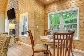 Un interior de madera con una mesa de comedor, sillas y una chimenea de piedra.