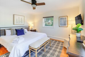 A bedroom with a bed, bedside tables, a bench, a ceiling fan, a window, and a TV on a stand. - Walk to Shops, Eats & Trails: Blowing Rock Escape! (Blowing Rock)