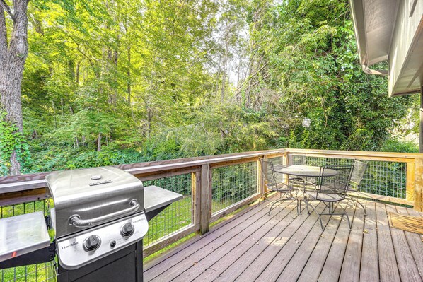 A deck with a grill, a table, and chairs, surrounded by a wooden railing and dense foliage. - Walk to Shops, Eats & Trails: Blowing Rock Escape! (Blowing Rock)