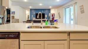 A modern kitchen with a stainless steel refrigerator, a double sink, and a dishwasher. - Spacious Home Near Dtwn PSL: Travel Nurses Welcome (Port St. Lucie)