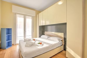 Ein Schlafzimmer mit einem Bett, einem Kleiderschrank und einem blauen Regalsystem.