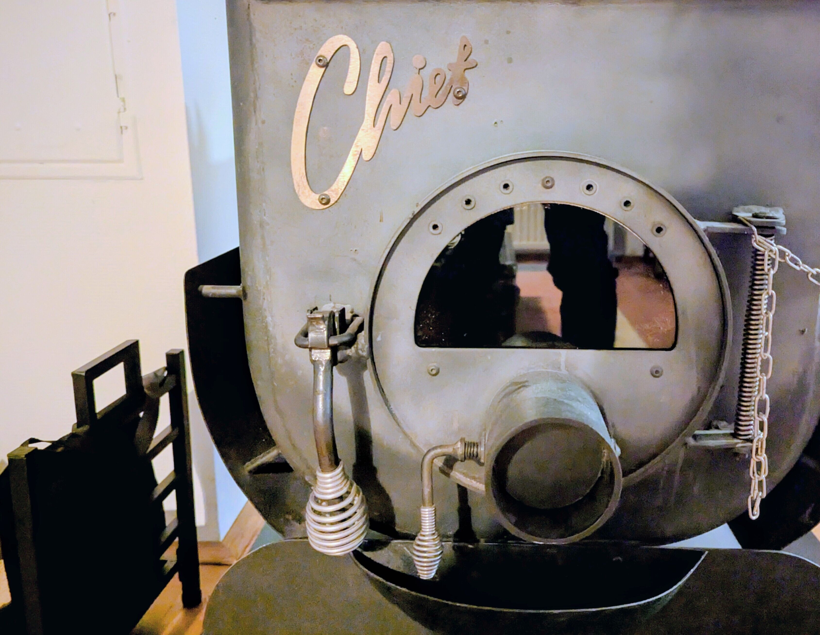 A vintage-style oven with the word 'Chic' on it, a metal handle, and a chain.