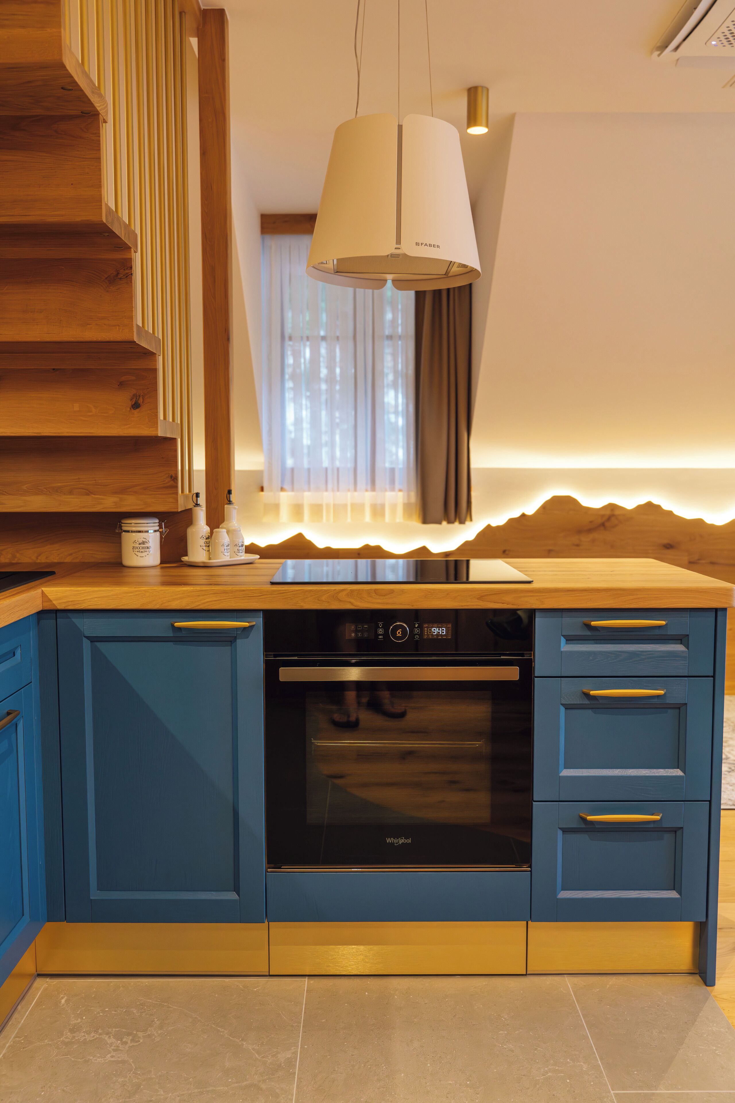 A modern kitchen with blue cabinetry, a built-in oven, and a dishwasher.