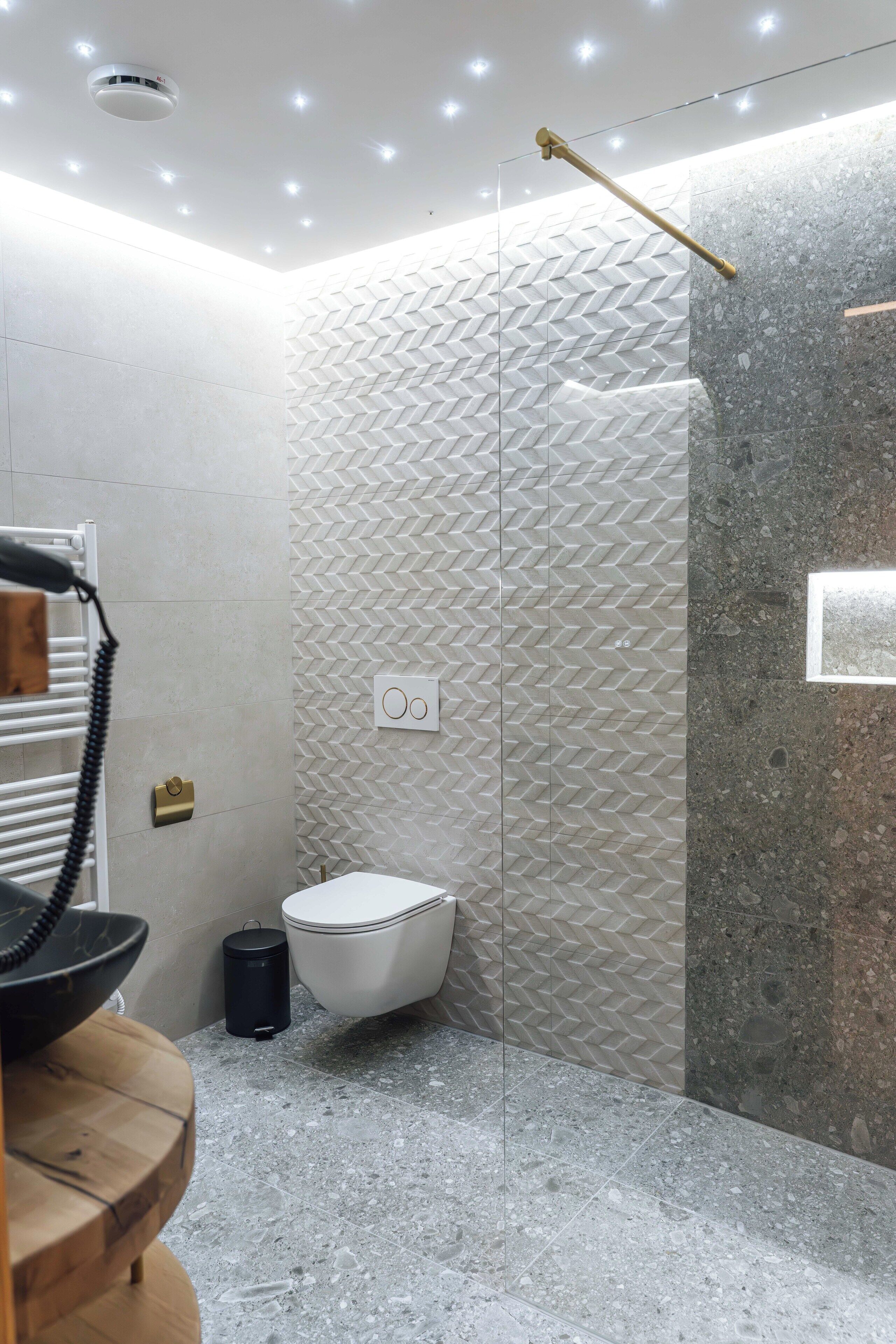 A modern bathroom with a shower, a toilet, and a sink.