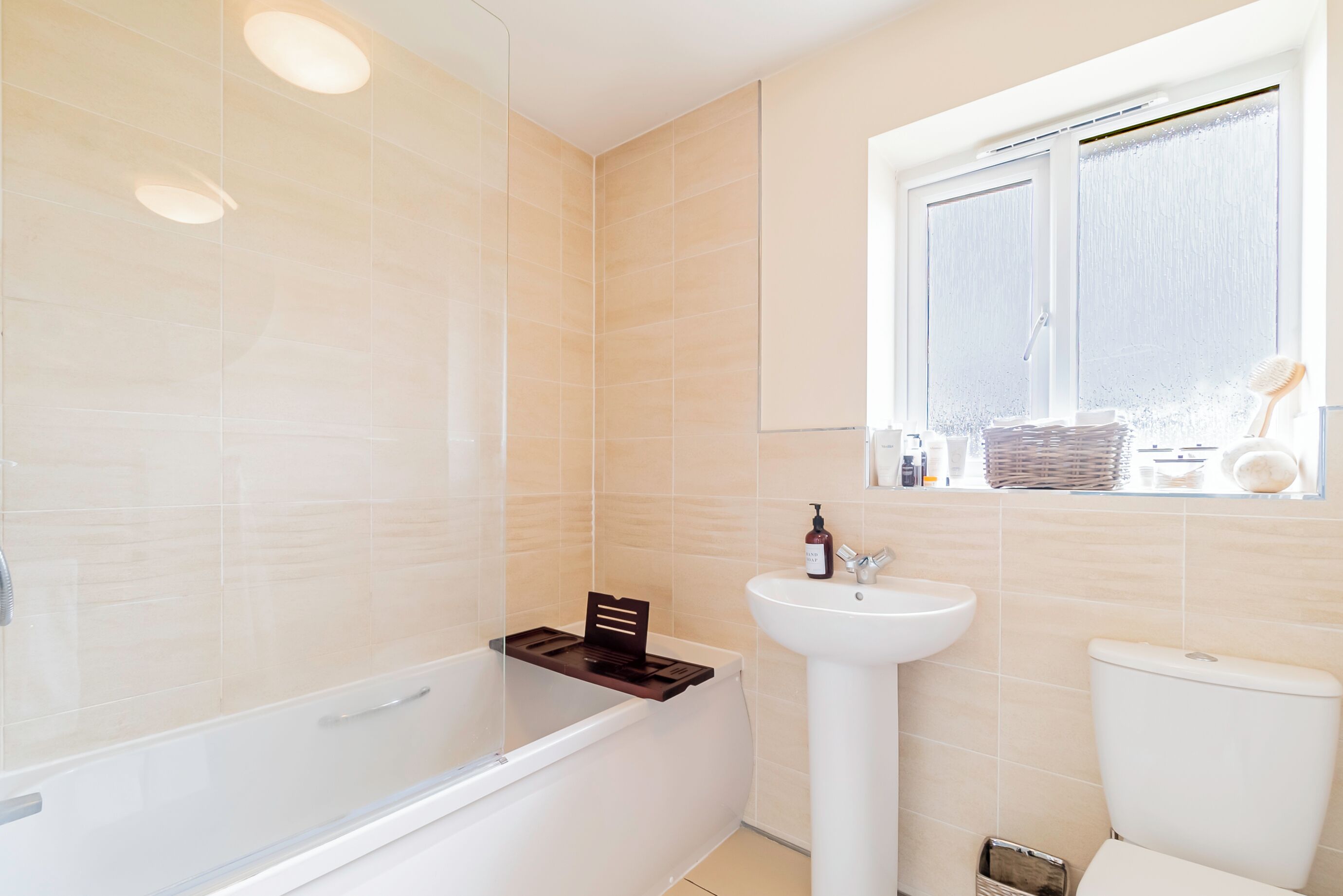 A modern bathroom with a bathtub, a sink, and a toilet.