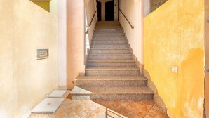 Un escalier muni d’une rampe, menant à une porte située en haut.