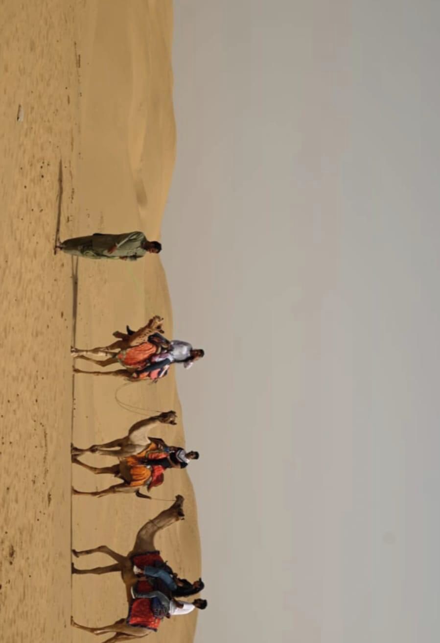 A desert landscape with a group of people in the distance.
