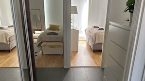 A modern, well-lit bedroom with two beds, a bedside table, and a small desk with a lamp. - Virpiniemen Maston Villa, Oulu (8 persons) (Oulu)
