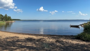 A calm lake with a sandy beach and a small boat. - Virpiniemen Maston Villa, Oulu (8 persons) (Oulu)
