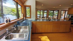 A kitchen with a large island, stainless steel sinks, and wooden cabinets. -  Temple's Sunset Harbor (Newbury)
