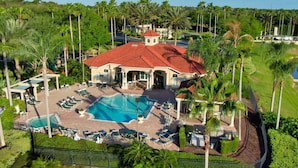 A resort with a central swimming pool, lounge areas, and palm trees. - 5BRDisney Villa w/ Pool,Game Room & Resort Access (Kisimmee)
