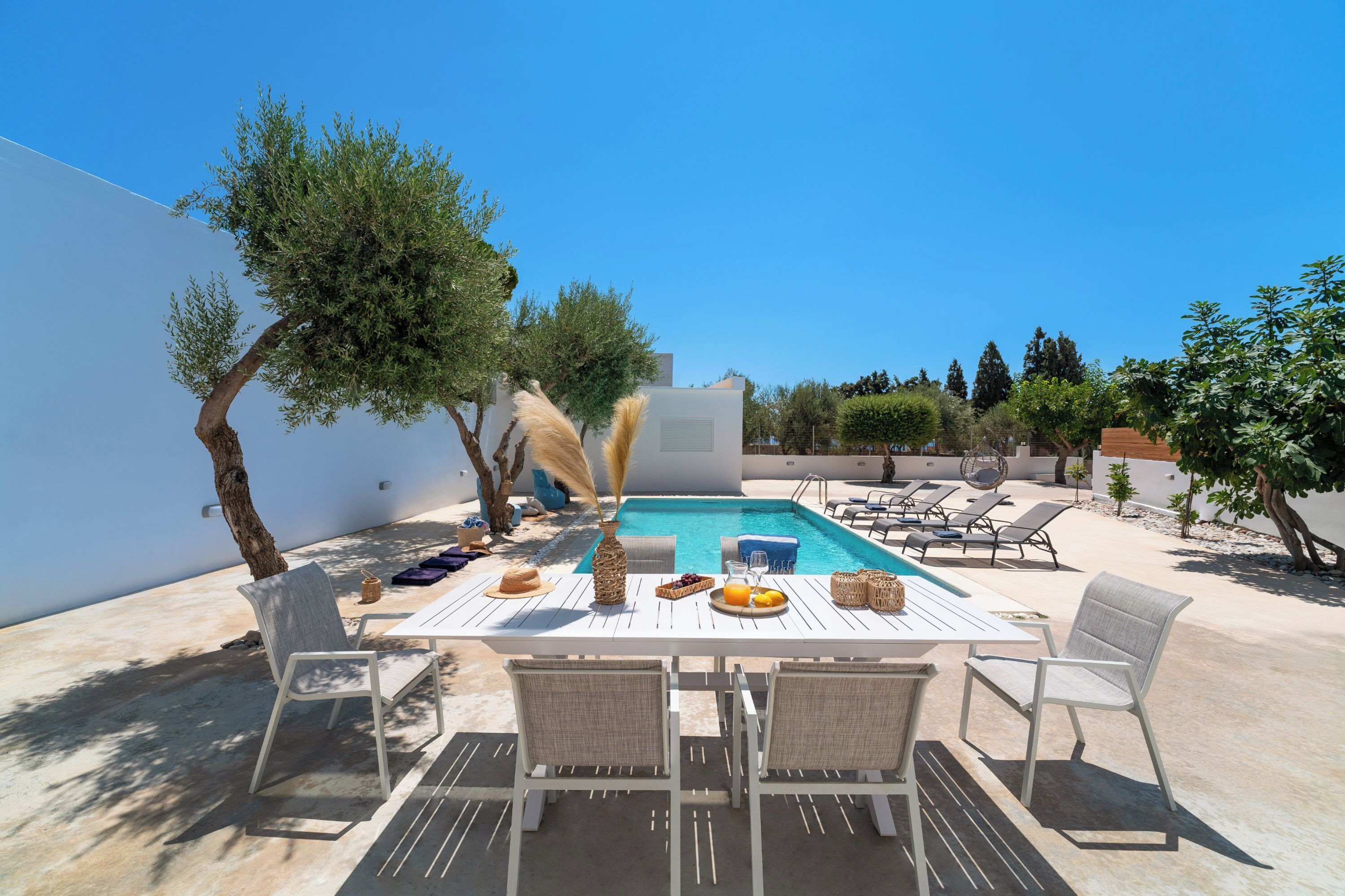 Un área de comedor junto a la piscina, con mesa y sillas.