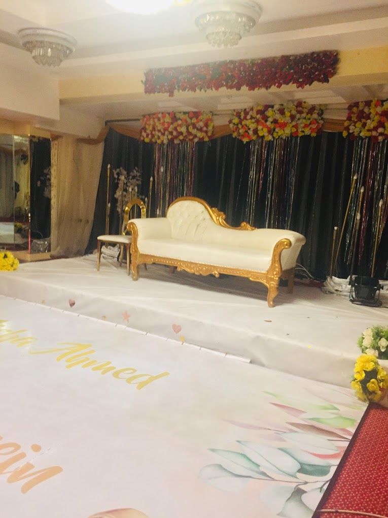 Une scène avec un canapé blanc et une table, décorée de fleurs et de draperies.