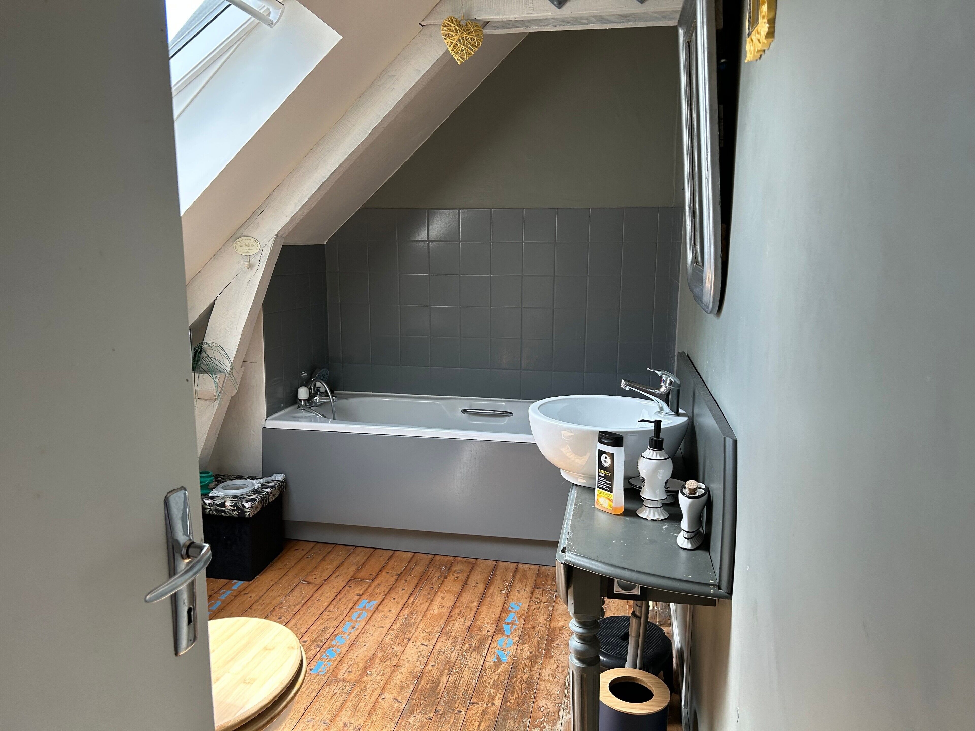 Ein kleines Badezimmer mit Badewanne, Waschbecken und Toilette.