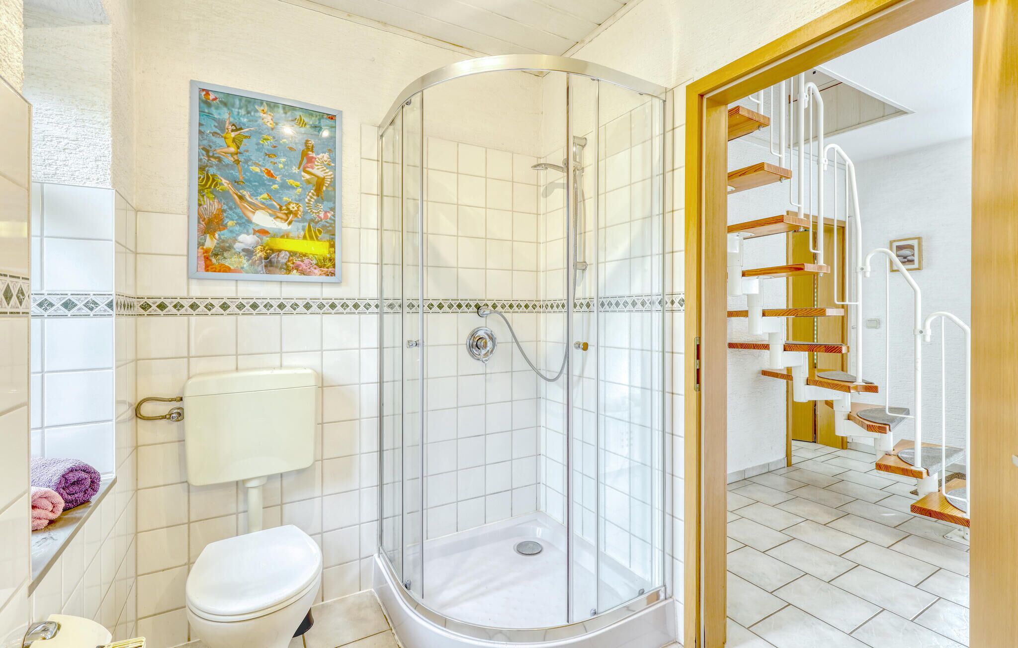 Et badeværelse med bruseniche, toilet og vask.