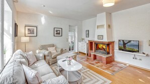 Una sala de estar con chimenea, sofá y televisor.