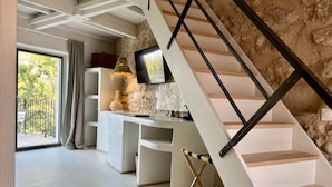 Un intérieur moderne avec un escalier, un bureau et un mur en pierre.